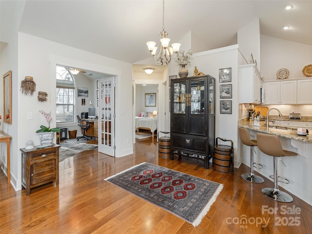 interior space with sink, dark hardwood / wood-style floors, an inviting chandelier, and vaulted ceiling