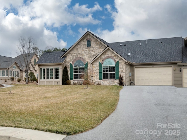 single story home featuring a front yard and a garage