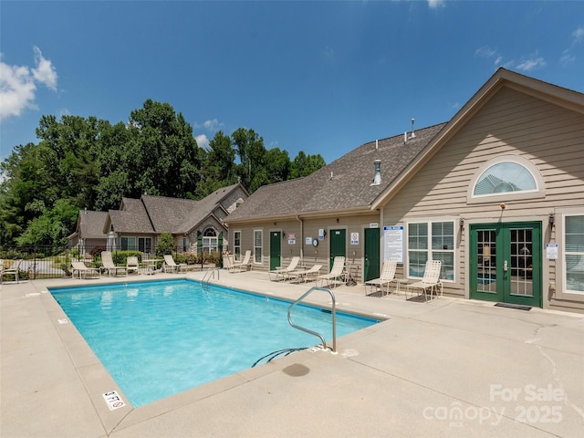 view of swimming pool with french doors and a patio area