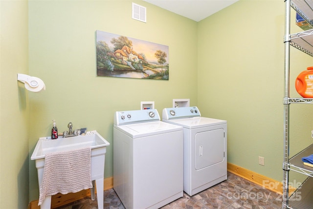 clothes washing area featuring sink and washing machine and dryer