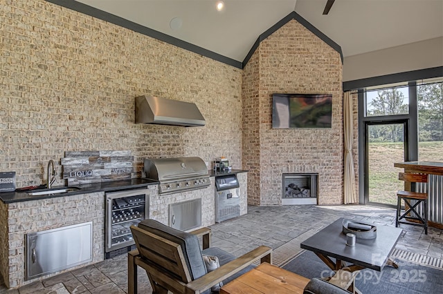 view of patio / terrace with area for grilling, beverage cooler, a fireplace, and sink