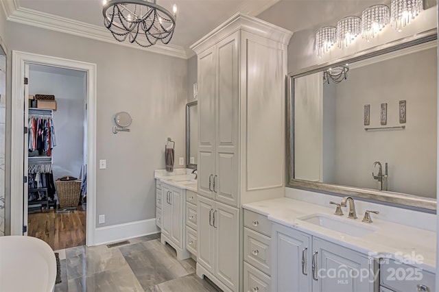 bathroom featuring vanity, crown molding, and a chandelier