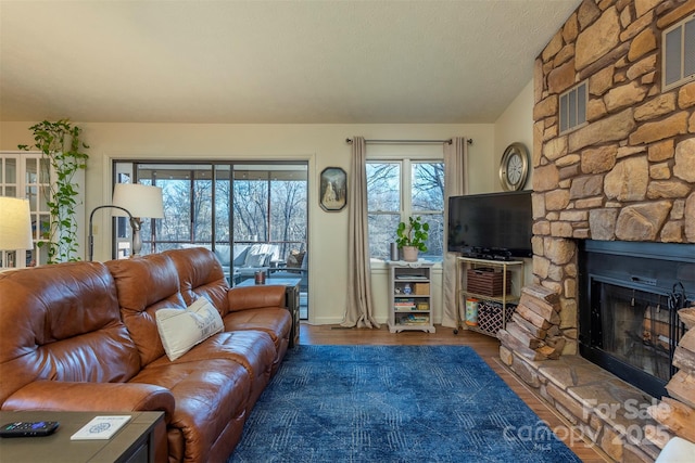 living room with hardwood / wood-style floors, a fireplace, and a textured ceiling