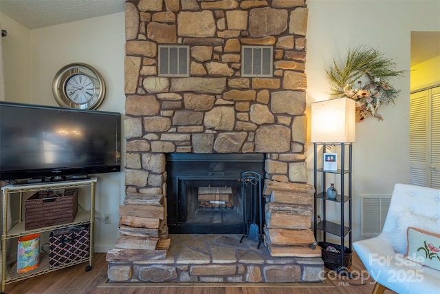 interior details with hardwood / wood-style flooring and a stone fireplace