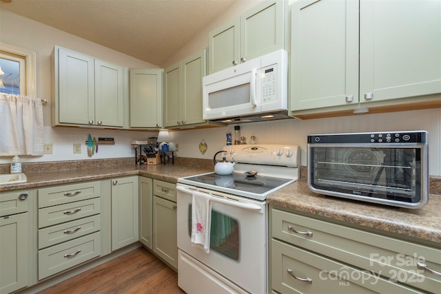 kitchen featuring lofted ceiling, dark hardwood / wood-style floors, a textured ceiling, and white appliances