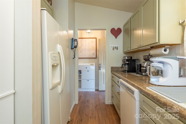 kitchen with a textured ceiling, white appliances, and light hardwood / wood-style floors