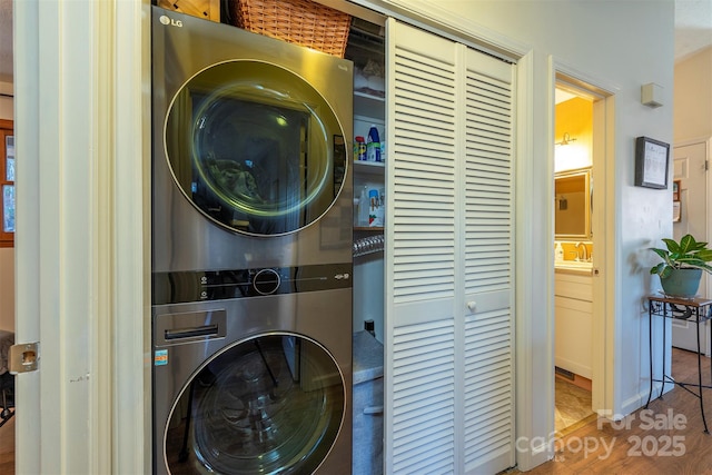 clothes washing area with stacked washer / dryer and sink