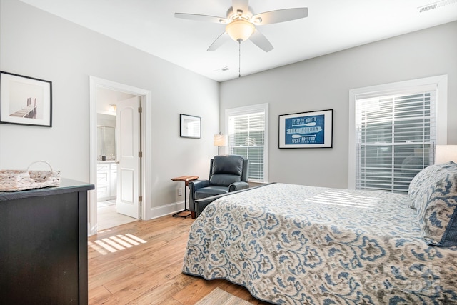 bedroom with ceiling fan, ensuite bathroom, and light hardwood / wood-style floors