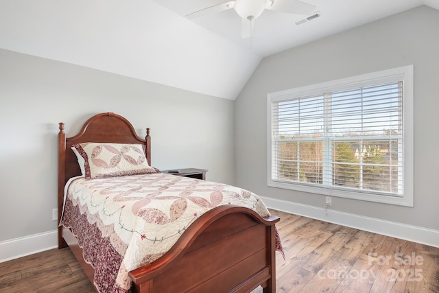 bedroom with hardwood / wood-style flooring, vaulted ceiling, and ceiling fan