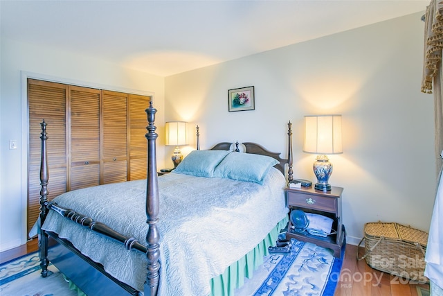 bedroom with a closet, baseboards, and wood finished floors