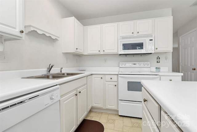 kitchen with white cabinetry, sink, and white appliances