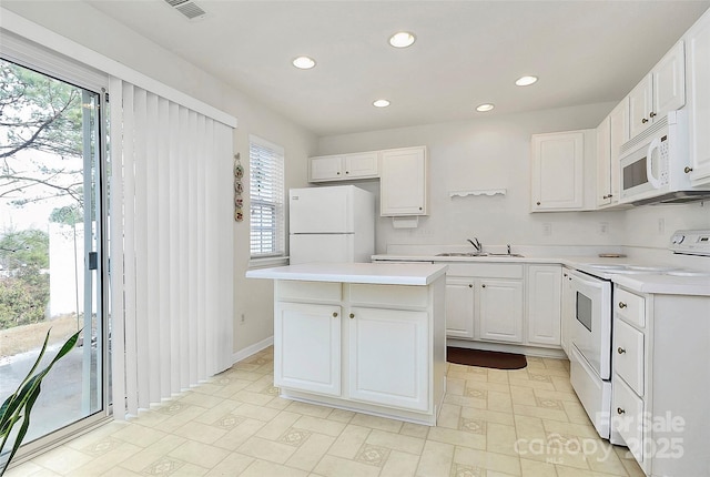 kitchen with white cabinetry, white appliances, a center island, and sink