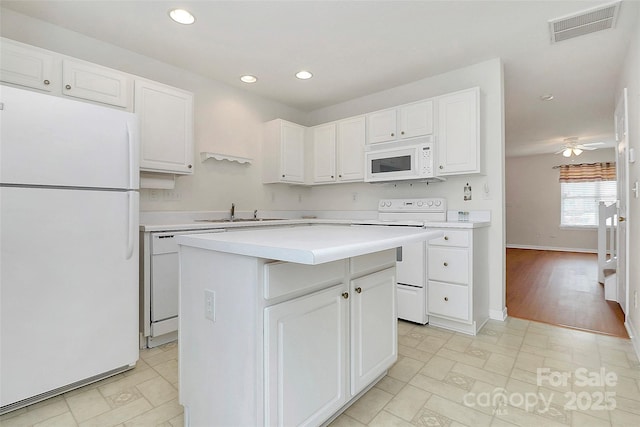 kitchen with a kitchen island, white cabinetry, sink, ceiling fan, and white appliances