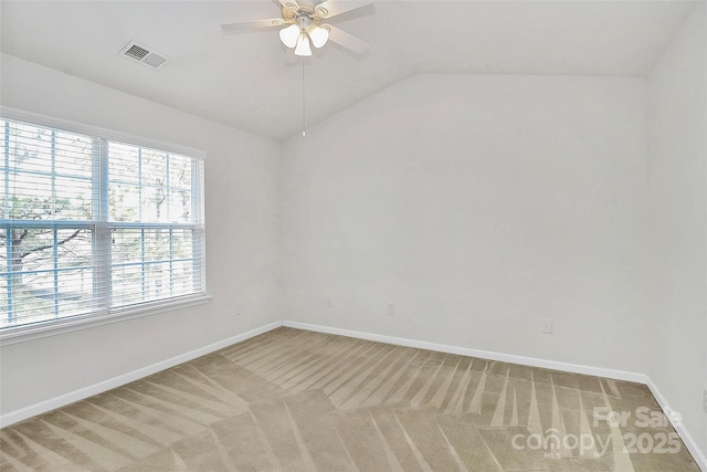 carpeted empty room with ceiling fan, vaulted ceiling, and a wealth of natural light