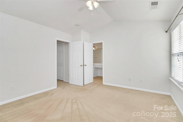 unfurnished bedroom with vaulted ceiling, light colored carpet, and ceiling fan