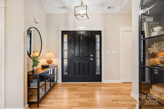 foyer entrance featuring a chandelier and hardwood / wood-style floors