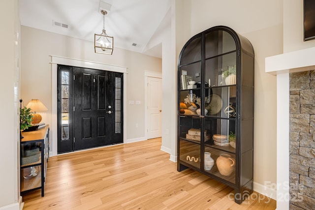 entryway with lofted ceiling and light wood-type flooring