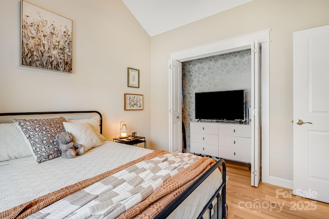 bedroom with lofted ceiling and light wood-type flooring