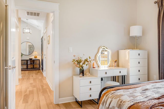 bedroom with lofted ceiling and light wood-type flooring