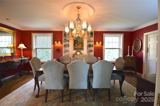 dining area featuring ornamental molding, wood finished floors, a wealth of natural light, and a notable chandelier