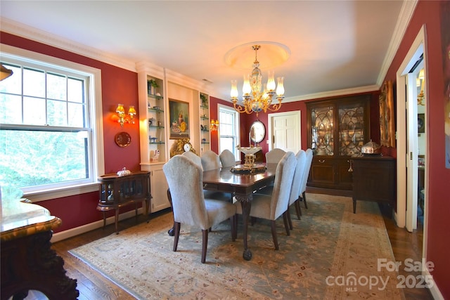 dining space featuring crown molding, baseboards, wood finished floors, and an inviting chandelier