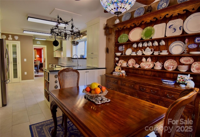 dining room with light tile patterned flooring and a notable chandelier