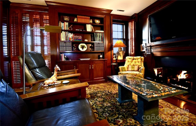 sitting room with a warm lit fireplace and visible vents