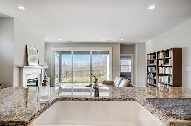 kitchen with light stone countertops and sink