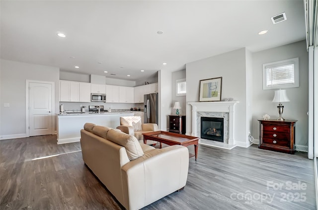 living room with a fireplace, light hardwood / wood-style flooring, and a wealth of natural light