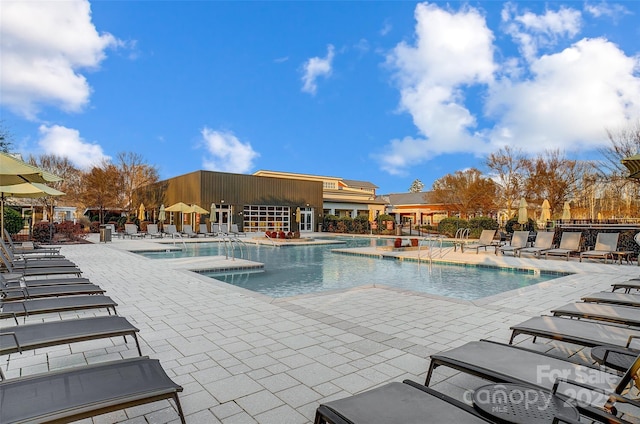 view of pool with a hot tub and a patio area