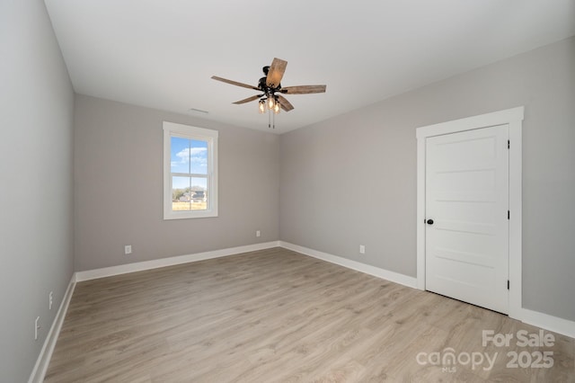 empty room with ceiling fan and light hardwood / wood-style flooring