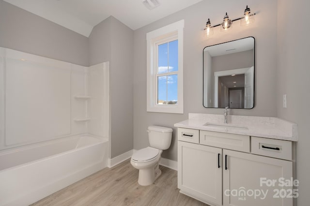 full bathroom with shower / bathing tub combination, hardwood / wood-style floors, vanity, and toilet