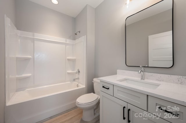 full bathroom with toilet, hardwood / wood-style floors, vanity, and  shower combination