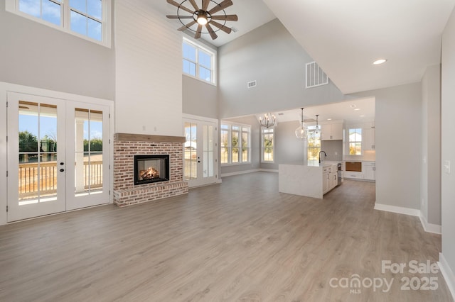 unfurnished living room with a wealth of natural light, light hardwood / wood-style floors, and french doors