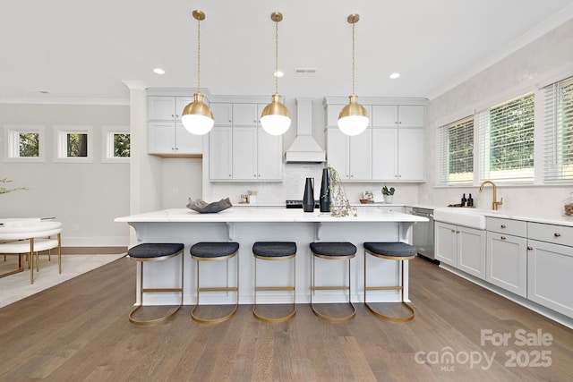 kitchen featuring white cabinetry, premium range hood, a kitchen island, and decorative light fixtures