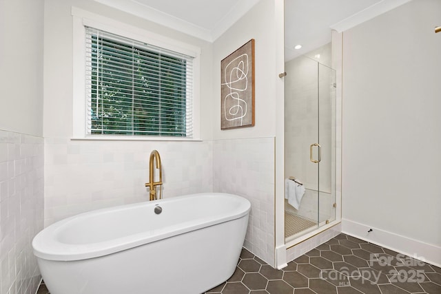 bathroom with tile patterned flooring, shower with separate bathtub, ornamental molding, and tile walls