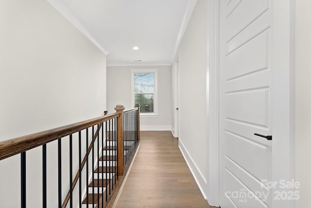 hallway with ornamental molding and light hardwood / wood-style flooring