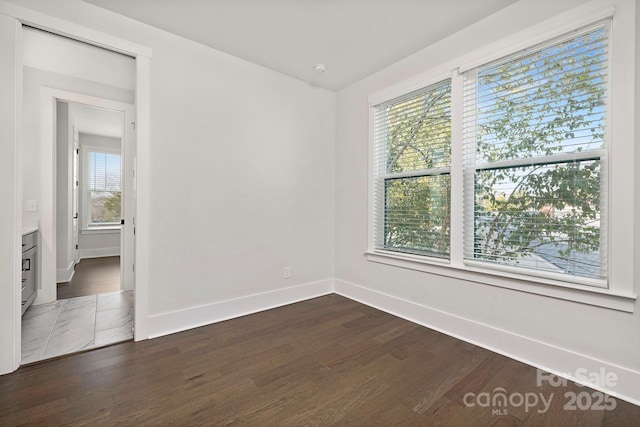 spare room featuring dark hardwood / wood-style floors and a wealth of natural light