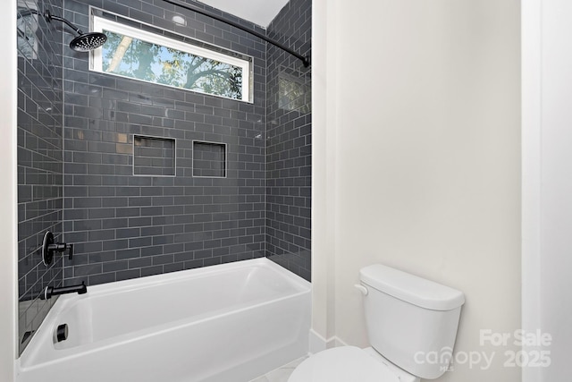 bathroom with toilet and tiled shower / bath combo