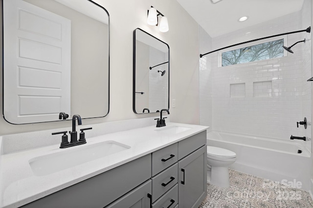 full bathroom featuring vanity, tile patterned flooring, toilet, and tiled shower / bath