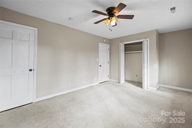 unfurnished bedroom featuring light colored carpet, a textured ceiling, and ceiling fan