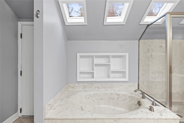 bathroom featuring a tub to relax in, vaulted ceiling, and built in features