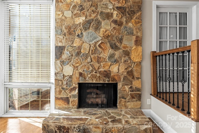 living room with plenty of natural light and a stone fireplace