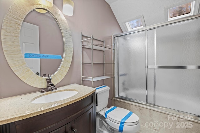 full bathroom with enclosed tub / shower combo, vaulted ceiling, vanity, and toilet