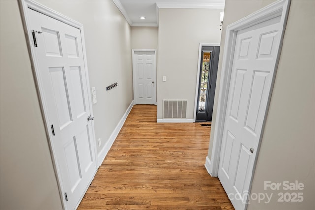 corridor featuring crown molding and light hardwood / wood-style flooring