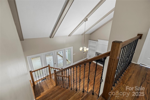 staircase featuring french doors, beamed ceiling, wood-type flooring, and a notable chandelier