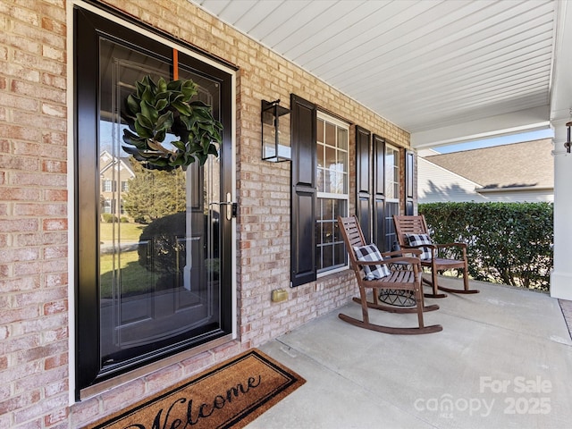 view of exterior entry featuring covered porch