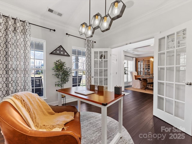 dining area featuring dark hardwood / wood-style flooring, a notable chandelier, and crown molding