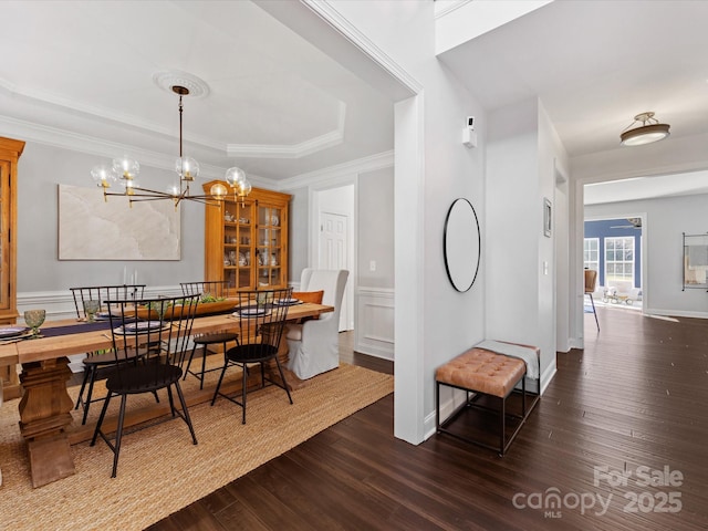 dining room with dark hardwood / wood-style flooring, ornamental molding, and a chandelier