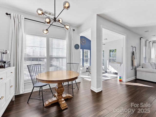 dining room with dark wood-type flooring and a chandelier